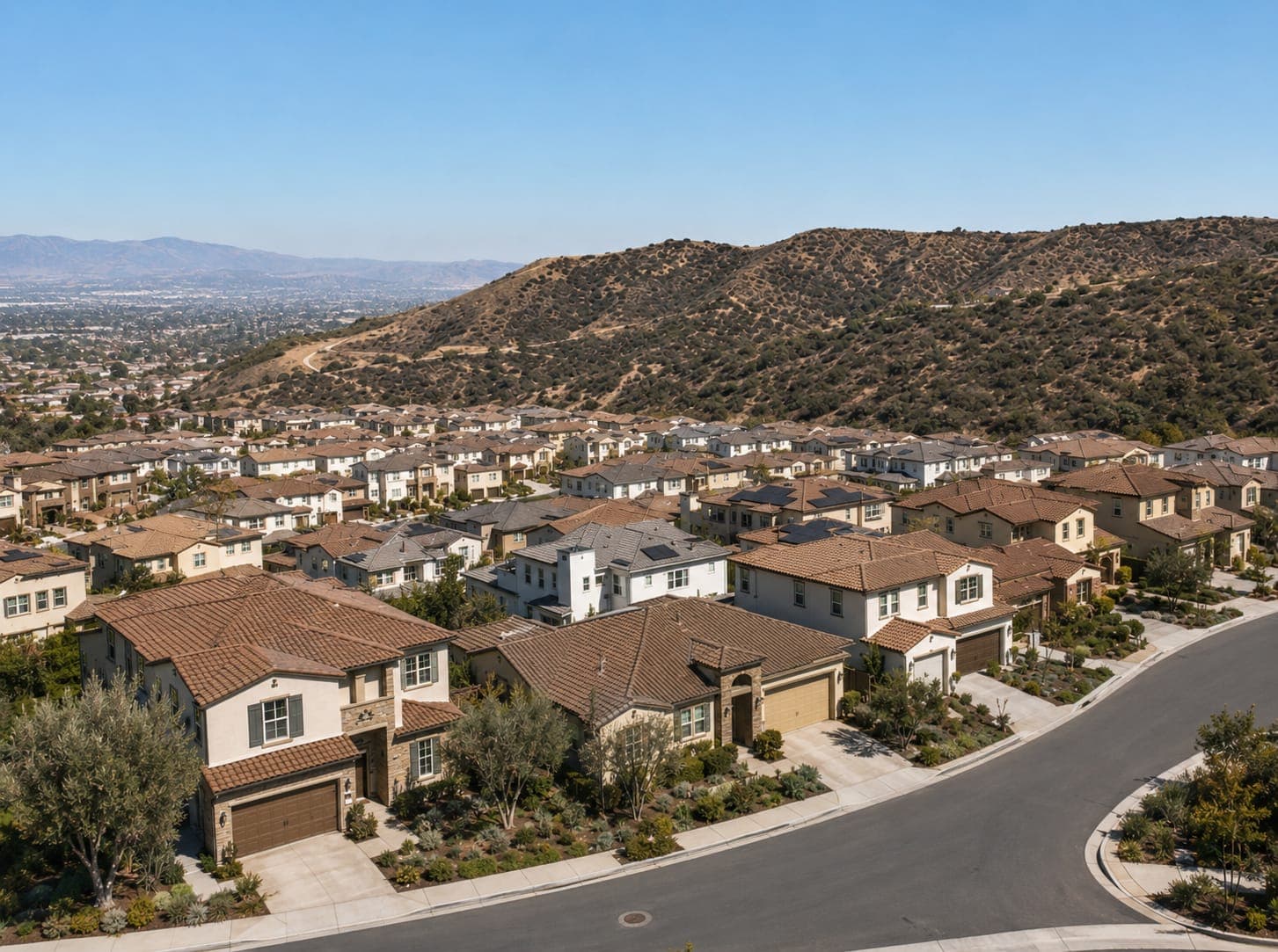 A Porter Ranch street with homes and the hillside behind